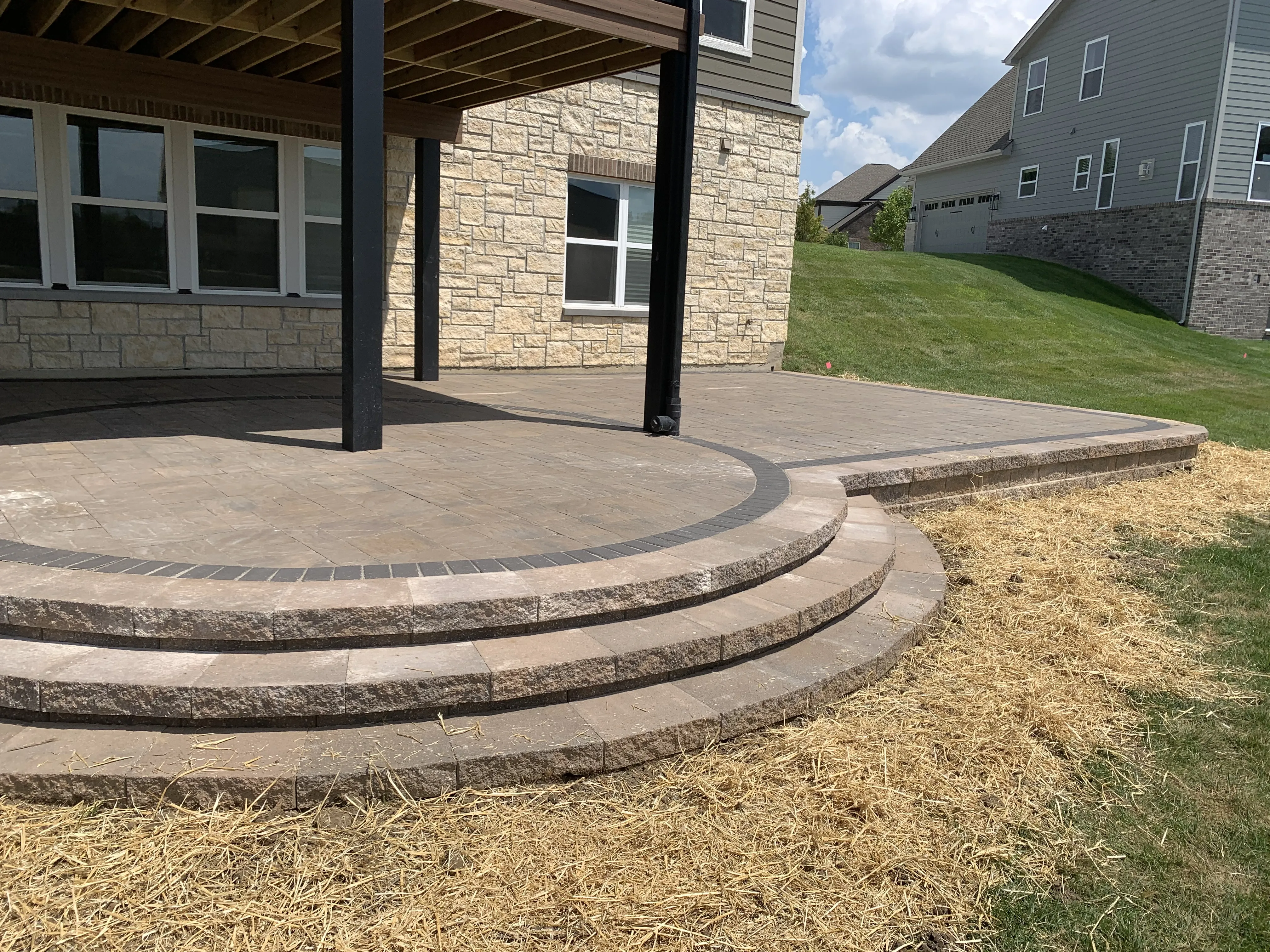 Custom raised paver patio with rounded steps built by Green Operations