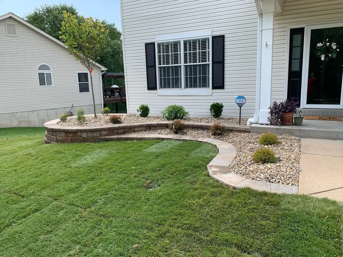 Front yard retaining wall with rock and shrub plantings