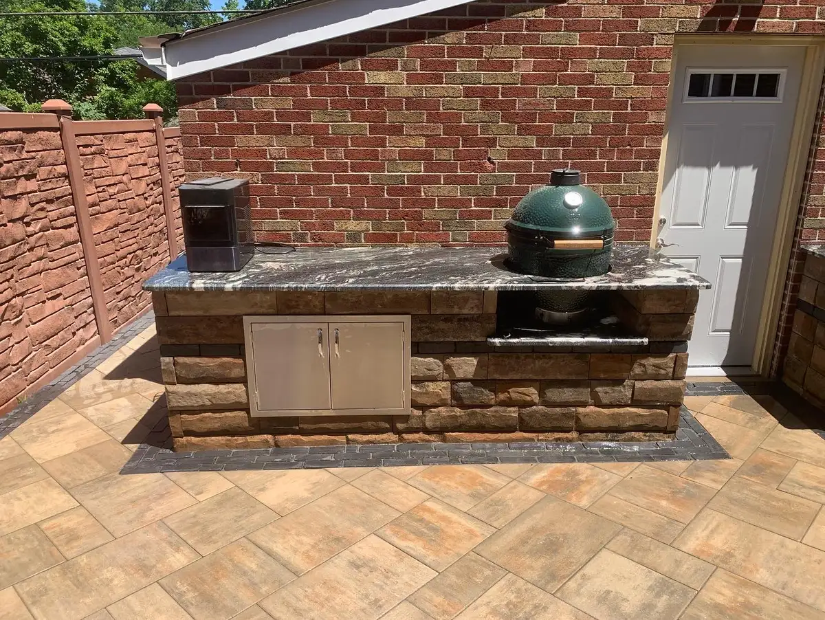 Outdoor kitchen island with Big Green Egg built into stone surround